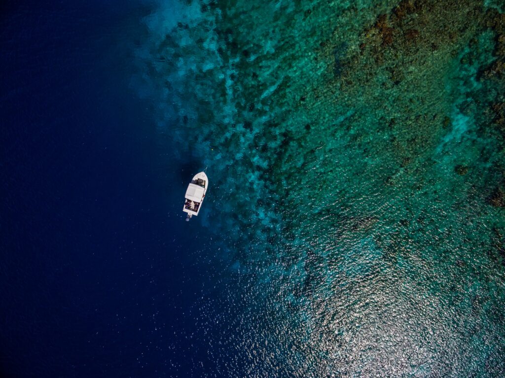 Barco a un costado de la playa y de un arrecife